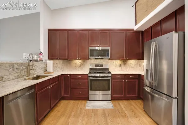a kitchen with stainless steel appliances granite countertop a refrigerator stove and sink
