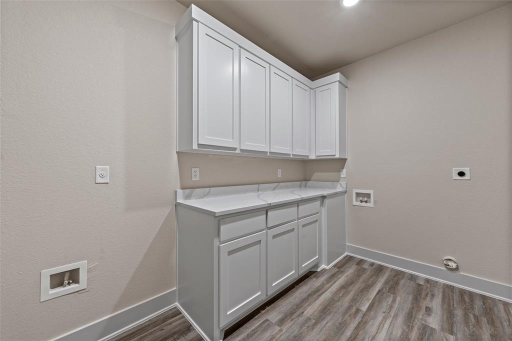 138 Dana Pt Road Lorena, TX 76655 - Photo 20 of 24 Laundry room featuring a white shaker-style cabinetry, a solid surface countertop, wood-finish flooring, recessed lighting, and neutral wall paint