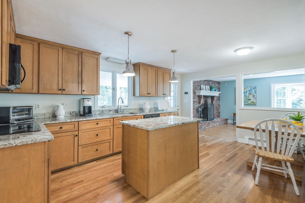 125 Rattlesnake Hill Road Andover, MA 01810 - Photo 7 of 28 a kitchen with stainless steel appliances granite countertop wooden cabinets a dining table and chairs with wooden floor