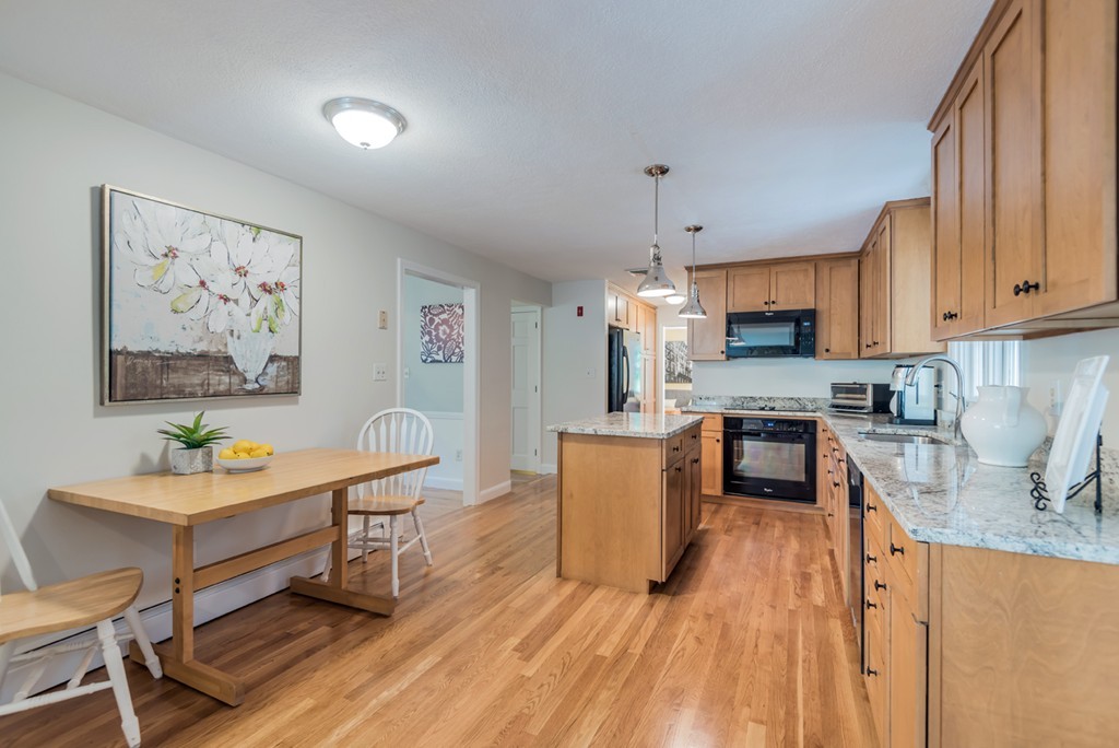 125 Rattlesnake Hill Road Andover, MA 01810 - Photo 8 of 28 a kitchen with stainless steel appliances a stove a sink a refrigerator and a dining table with wooden floor