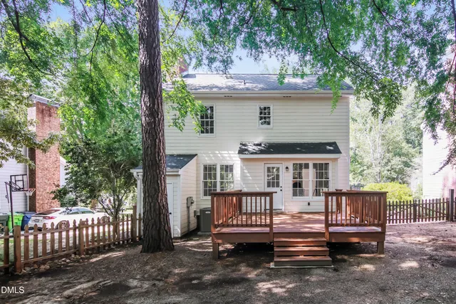 a view of a deck with a table and chairs and a large tree