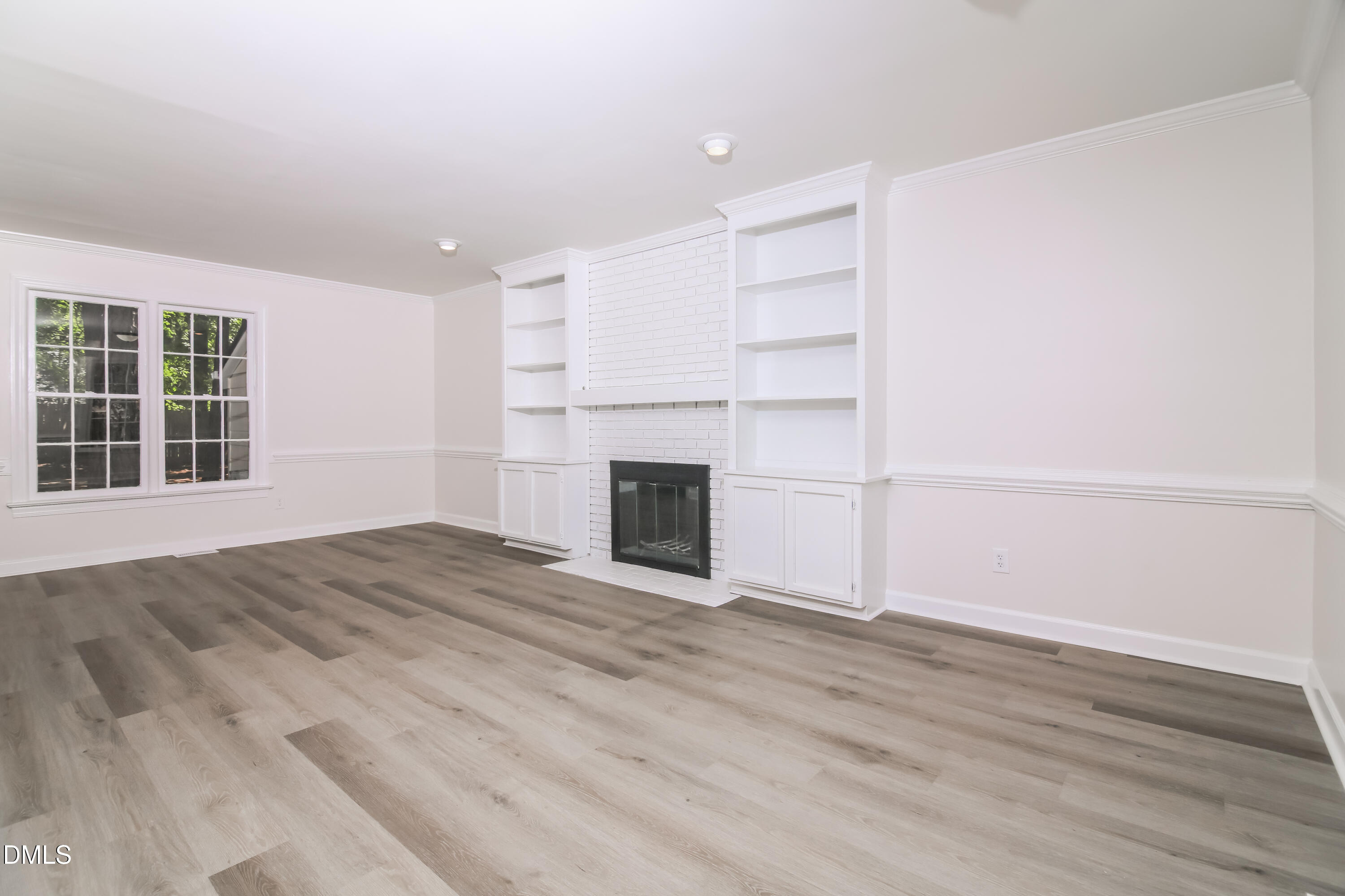 4416 Lancashire Drive Raleigh, NC 27613 - Photo 2 of 15 a view of empty room with wooden floor and fireplace
