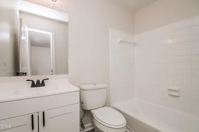 a bathroom with a sink toilet vanity and shower