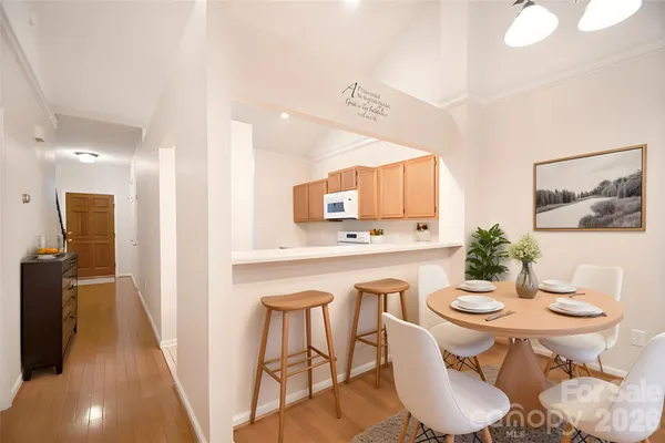 a kitchen with stainless steel appliances a dining table and chairs