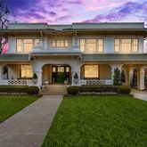 a front view of a house with a garden and yard