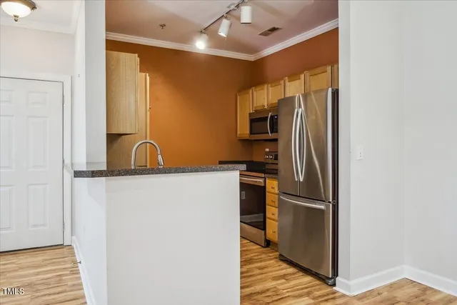 a kitchen with stainless steel appliances granite countertop a sink and a refrigerator