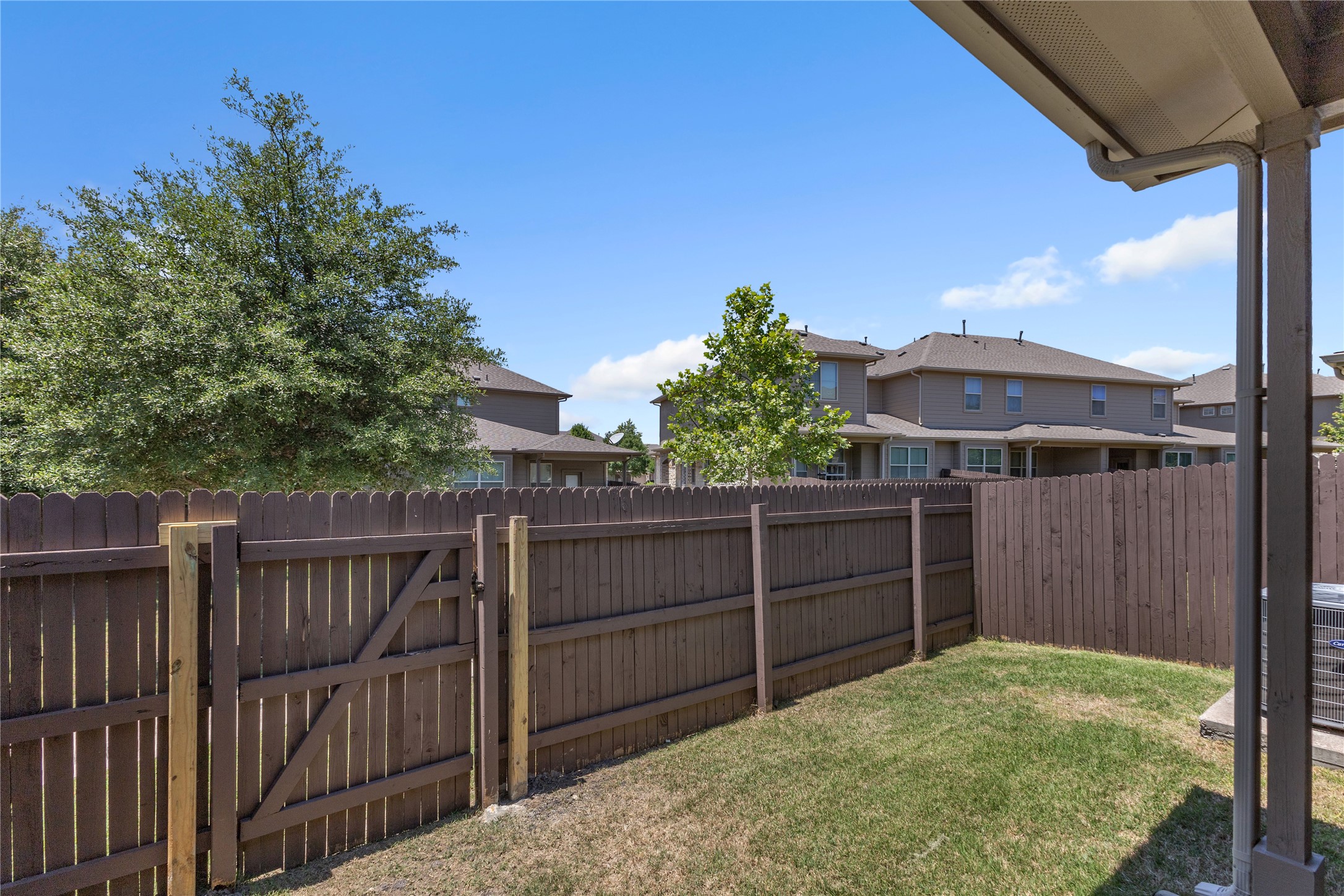 2880 Donnell Drive, Unit 2003 Round Rock, TX 78664 - Photo 31 of 31 Private backyard featuring a wood privacy fence with gate, a small grass area, and a covered patio structure