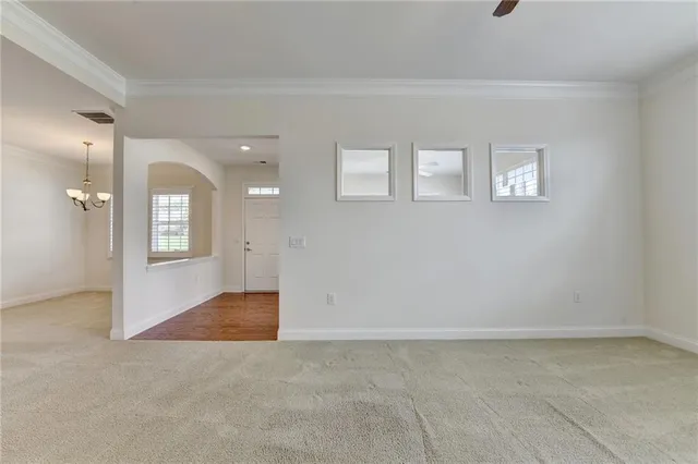 a view of kitchen with stainless steel appliances granite countertop a refrigerator a oven a sink and white cabinets with wooden floor