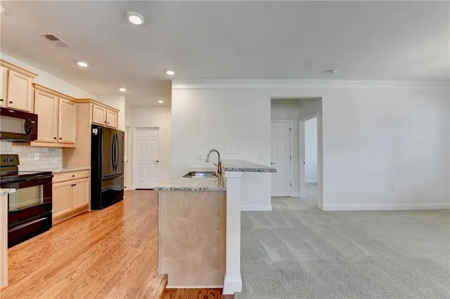 a kitchen with stainless steel appliances granite countertop a stove a sink and a refrigerator