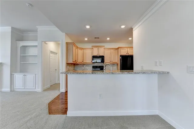 a kitchen with stainless steel appliances granite countertop wooden cabinets a stove a sink and a microwave