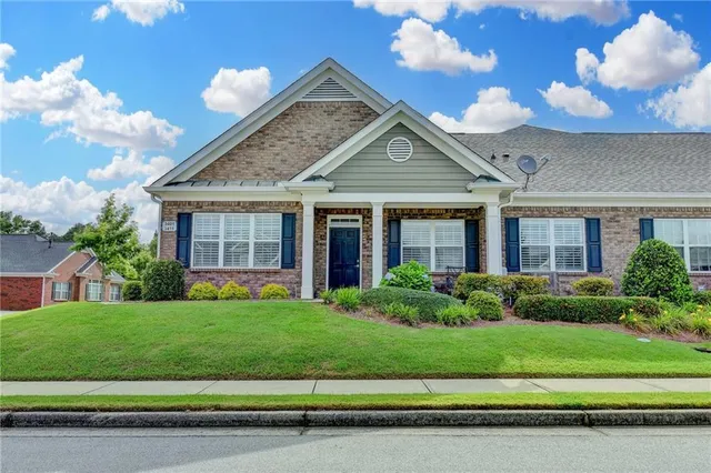 a front view of a house with a yard and potted plants