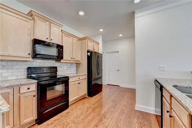a kitchen with granite countertop cabinets stainless steel appliances a sink and a window