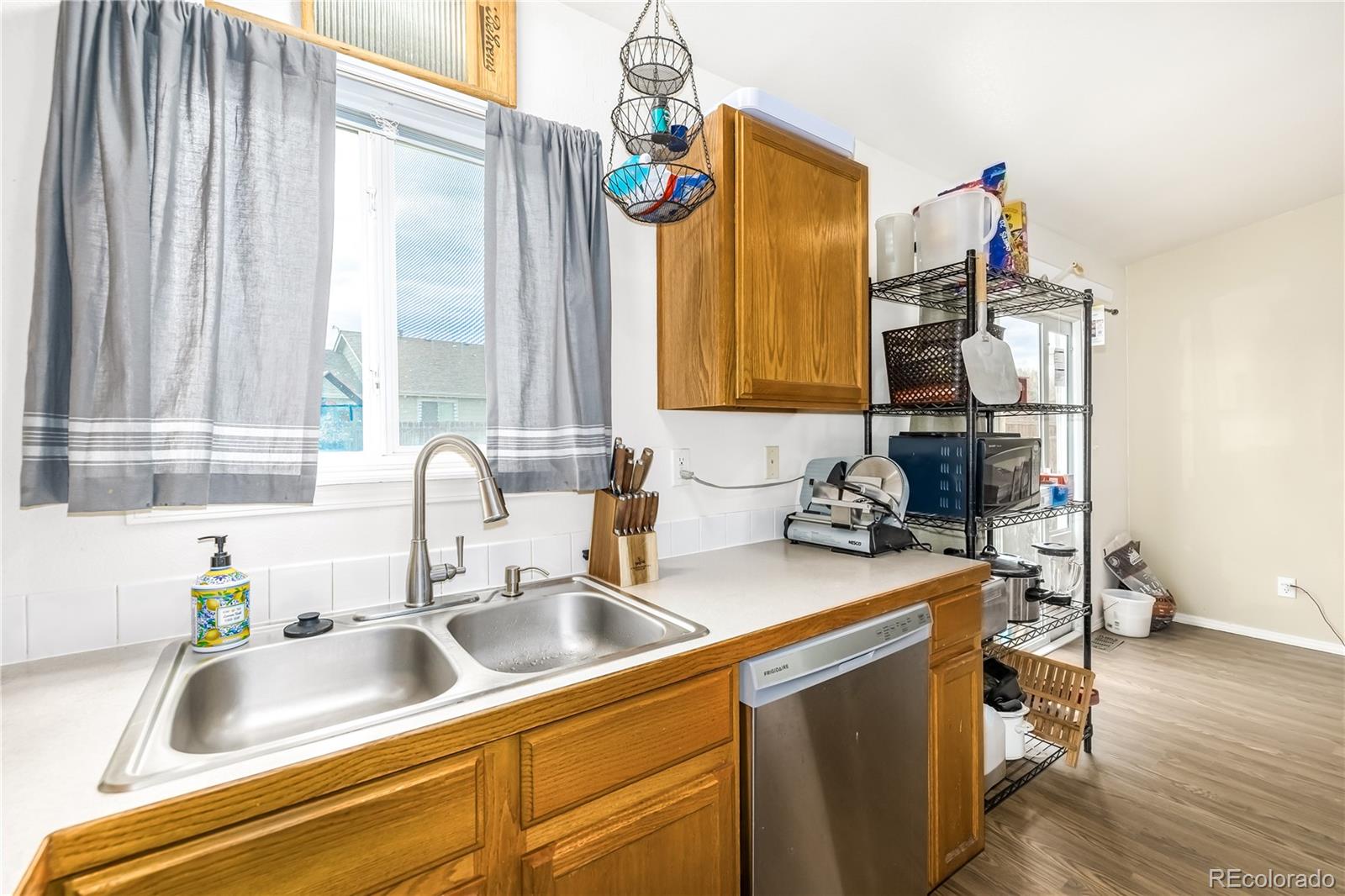 4005 Eagles Nest Drive Evans, CO 80620 - Photo 9 of 26 a kitchen with a sink cabinets and a wooden floor