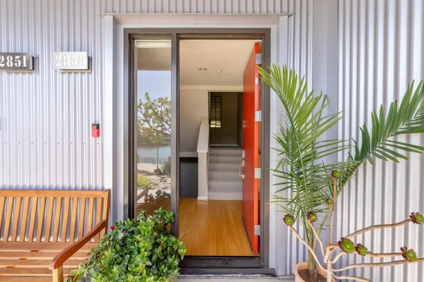 a porch with a potted plant in front of door