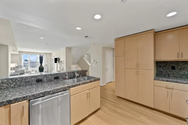 a kitchen with stainless steel appliances granite countertop a sink and cabinets