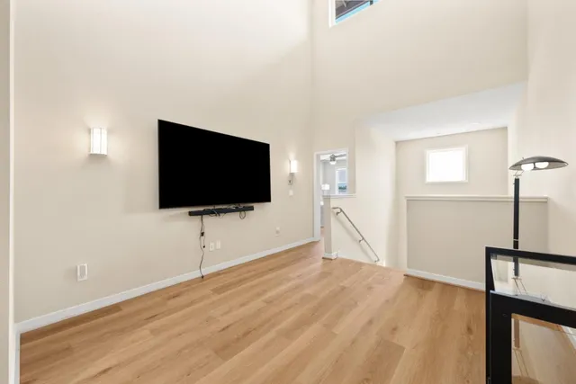 a living room with hardwood and a flat screen tv