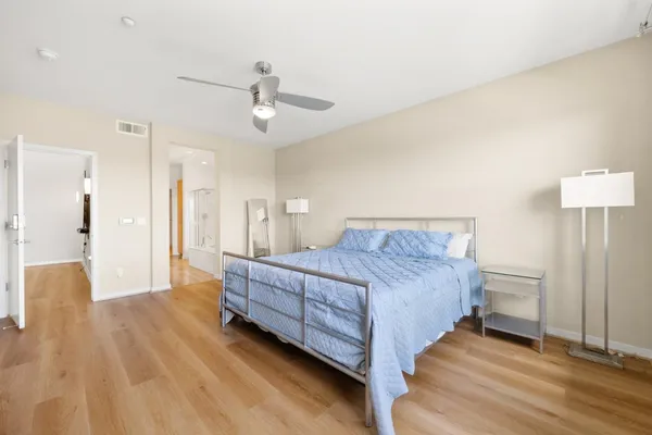 a spacious bedroom with a bed and a chandelier
