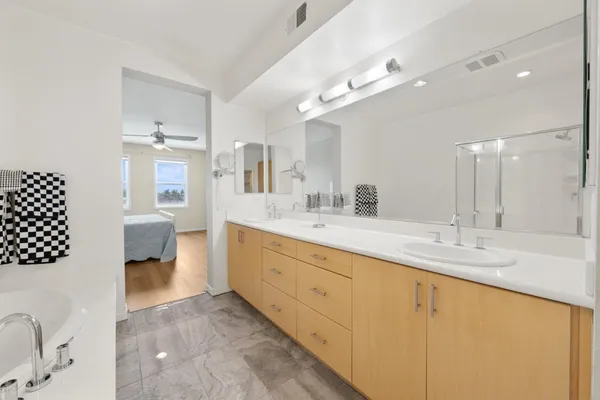 a spacious bathroom with a granite countertop sink a toilet a mirror and shower