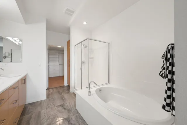 a bathroom with a tub sink and mirror
