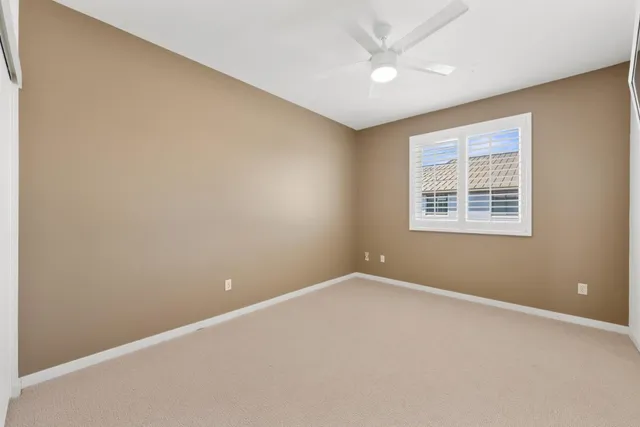 an empty room with a ceiling fan and a window