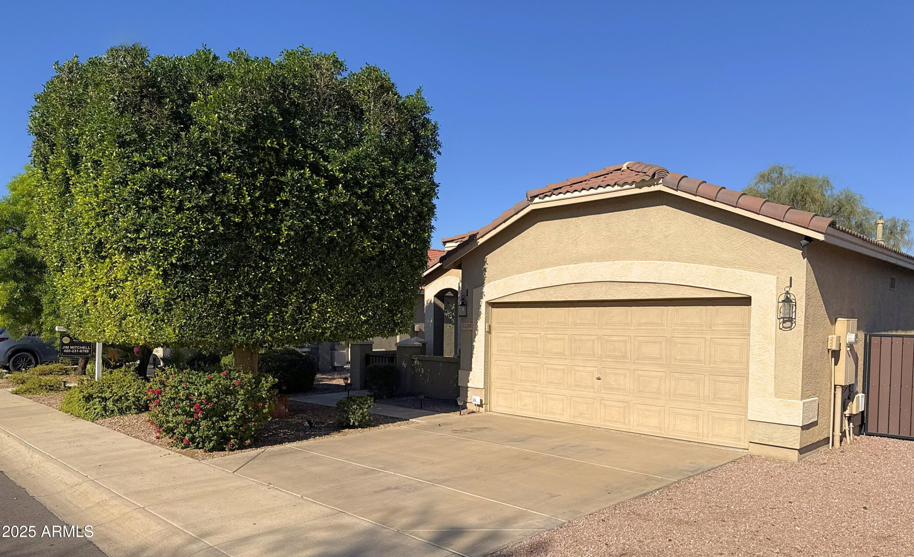 1126 East Pedro Road Phoenix, AZ 85042 - Photo 1 of 34 a view of a house with a small yard and a garage