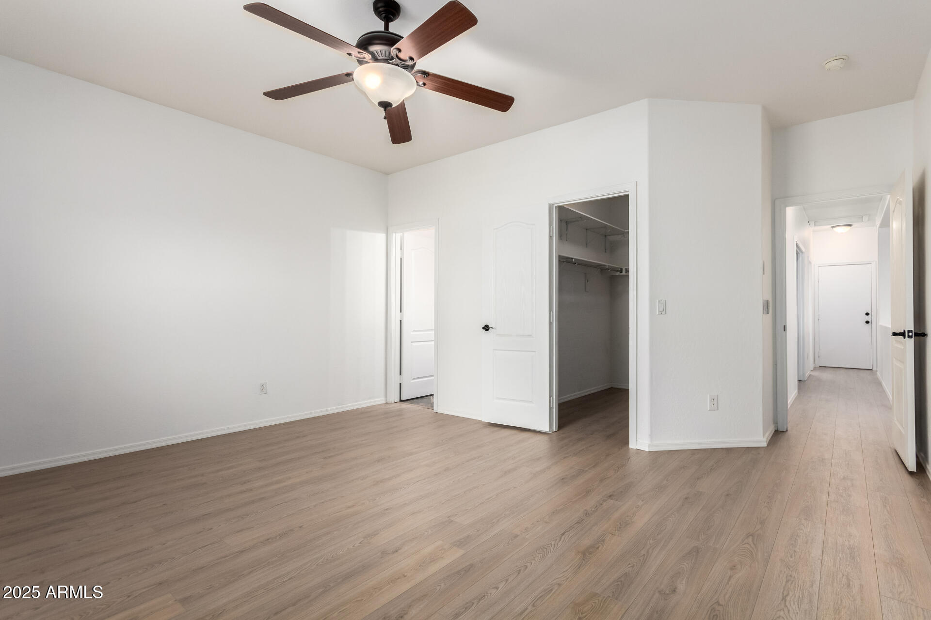 1126 East Pedro Road Phoenix, AZ 85042 - Photo 13 of 34 an empty room with wooden floor and ceiling fan