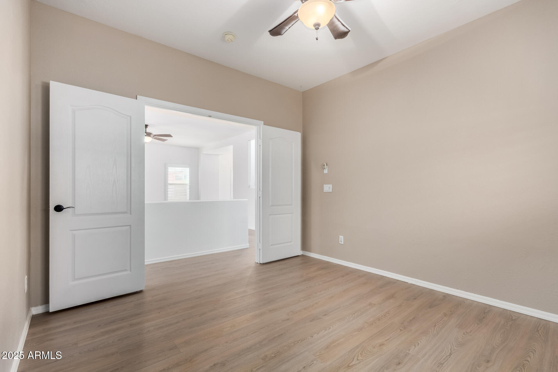 1126 East Pedro Road Phoenix, AZ 85042 - Photo 20 of 34 an empty room with wooden floor and ceiling fan
