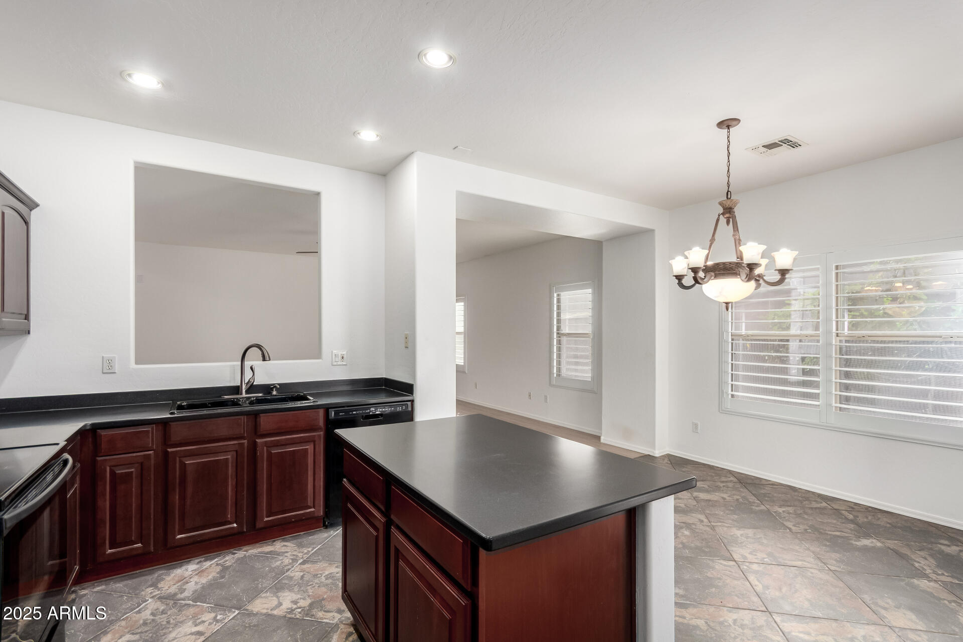 1126 East Pedro Road Phoenix, AZ 85042 - Photo 8 of 34 a kitchen with kitchen island granite countertop a sink cabinets and window