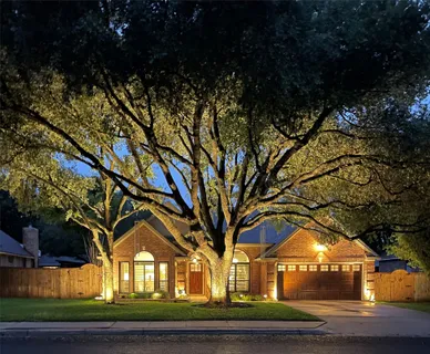 a front view of a house with a garden and trees