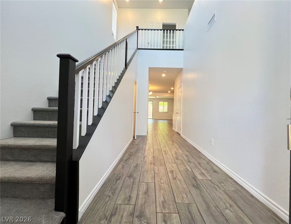 925 Bayberry Ridge Street Henderson, NV 89052 - Photo 4 of 27 Enter into a light-filled corridor, where sleek wood-look flooring guides you past a striking staircase.