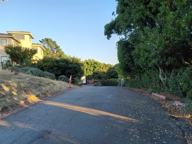 a view of a road with a house in the background