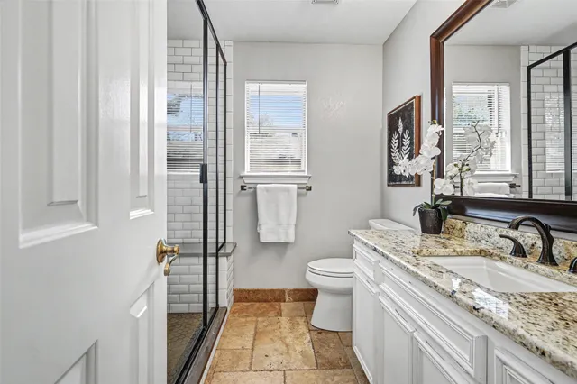 a bathroom with a granite countertop sink toilet and shower