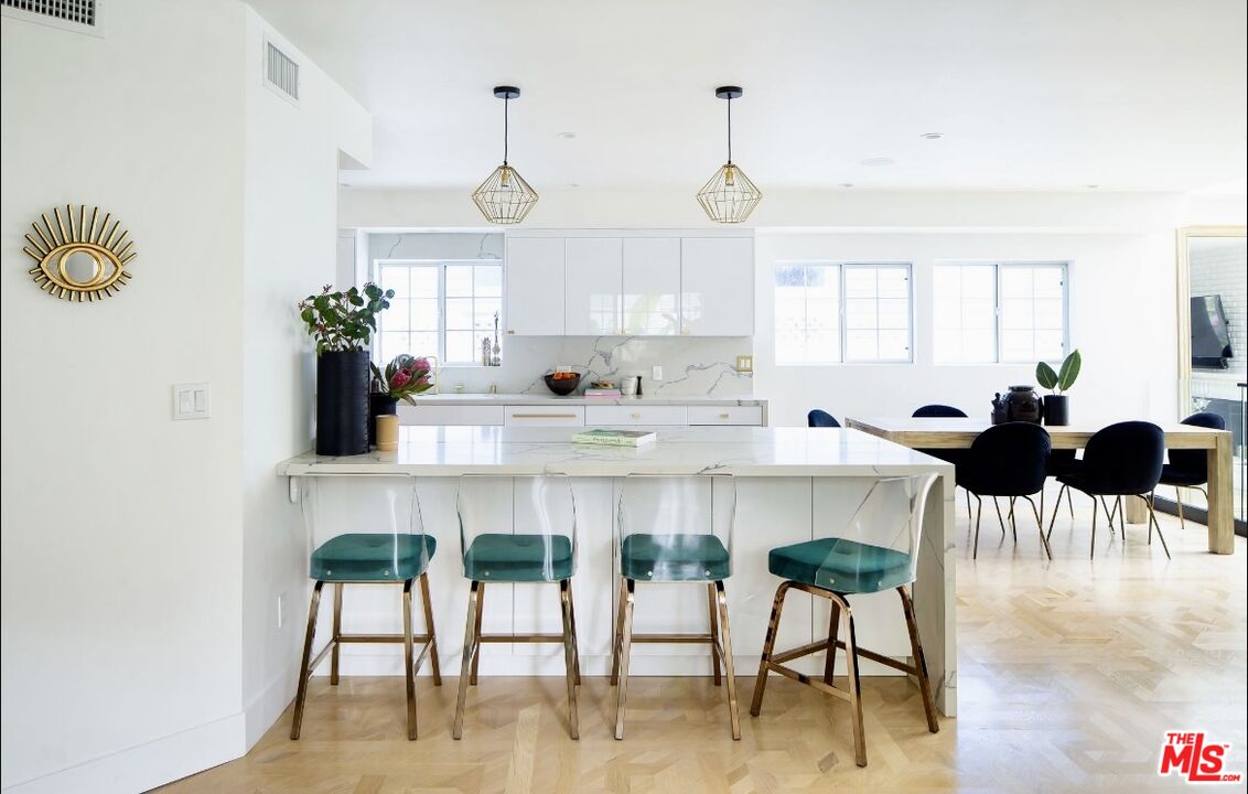 138 Roma Court Marina del Rey, CA 90292 - Photo 11 of 38 a kitchen with stainless steel appliances kitchen island a table and chair