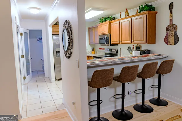 a kitchen with kitchen island granite countertop a sink a stove and cabinets