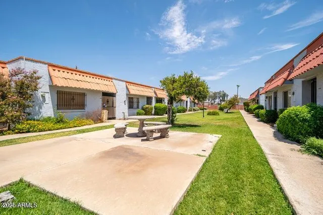 a view of a house with a yard patio and fire pit