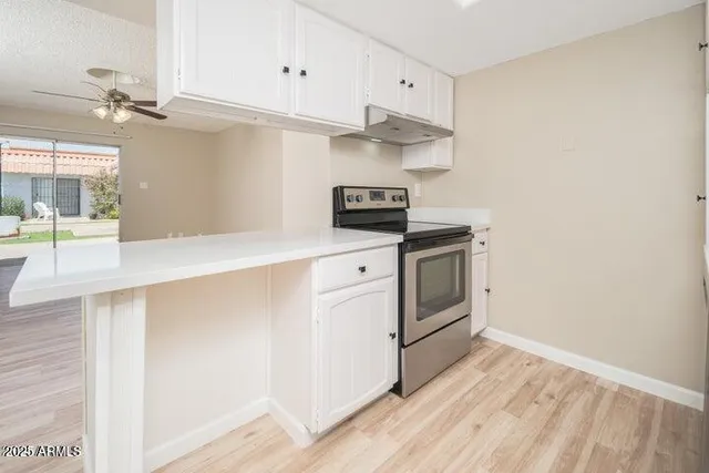 a kitchen with white cabinets and white appliances