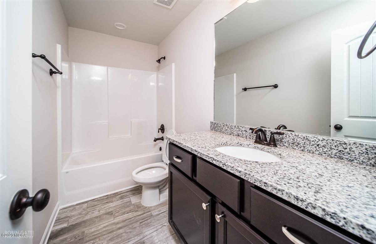 339 Walnut Grove Road Gray, GA 31032 - Photo 23 of 30 a bathroom with a granite countertop sink a toilet a mirror and shower