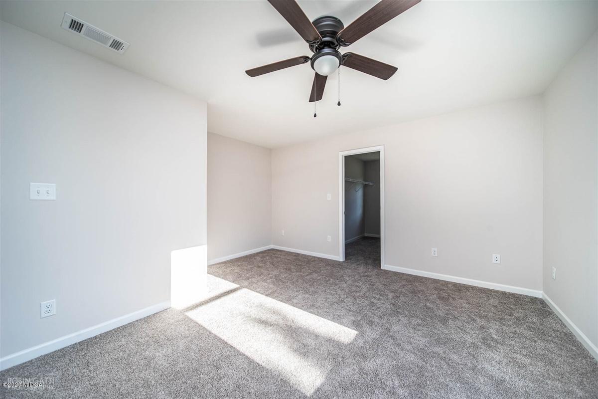 339 Walnut Grove Road Gray, GA 31032 - Photo 28 of 30 an empty room with a ceiling fan and carpet