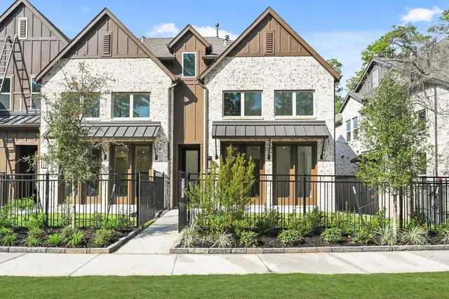 a front view of a house with a yard and potted plants