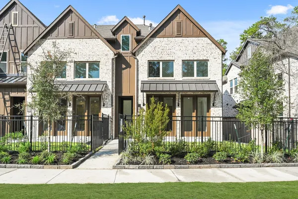 a front view of a house with a yard and potted plants