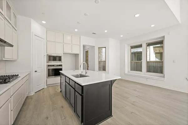 a kitchen with counter top space sink stove and refrigerator