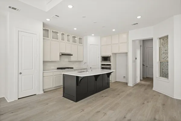 a kitchen with stainless steel appliances granite countertop a stove and a refrigerator