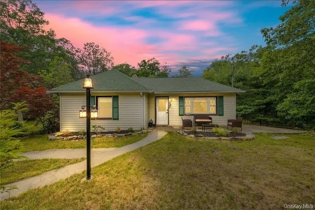 a view of a house with backyard and sitting area