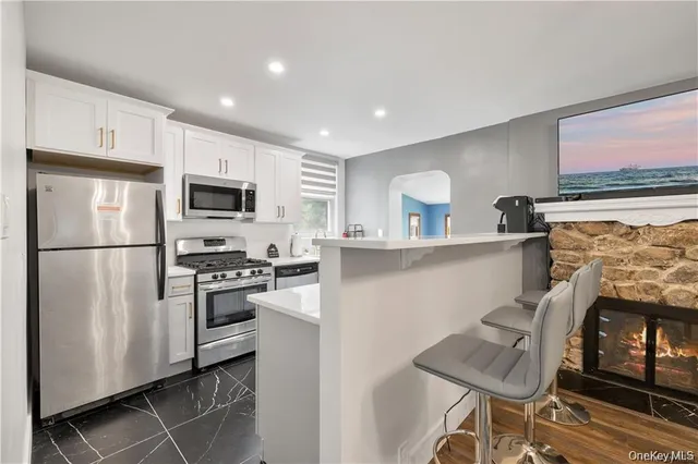 a kitchen with stainless steel appliances granite countertop a refrigerator sink and stove