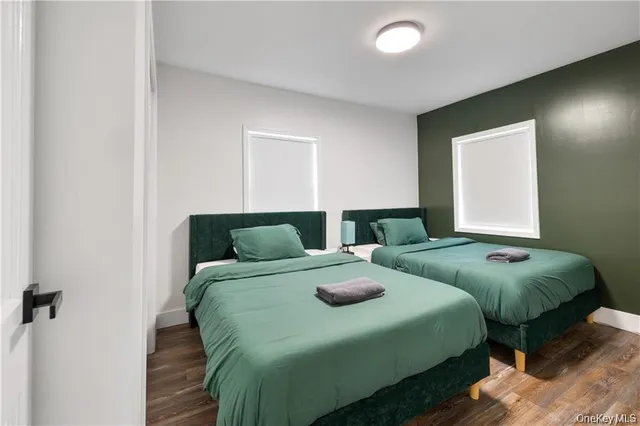 a bedroom with two beds and a potted plant