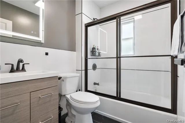 a bathroom with a sink a toilet and a mirror