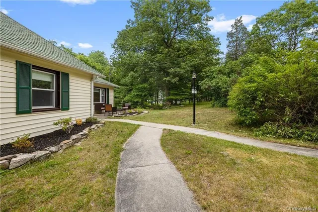 a backyard of a house with table and chairs
