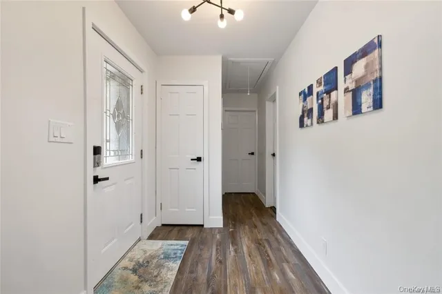 a view of a hallway with wooden floor and closet