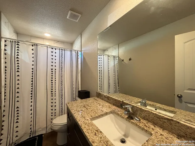 a bedroom with a bed and a lamp on dresser