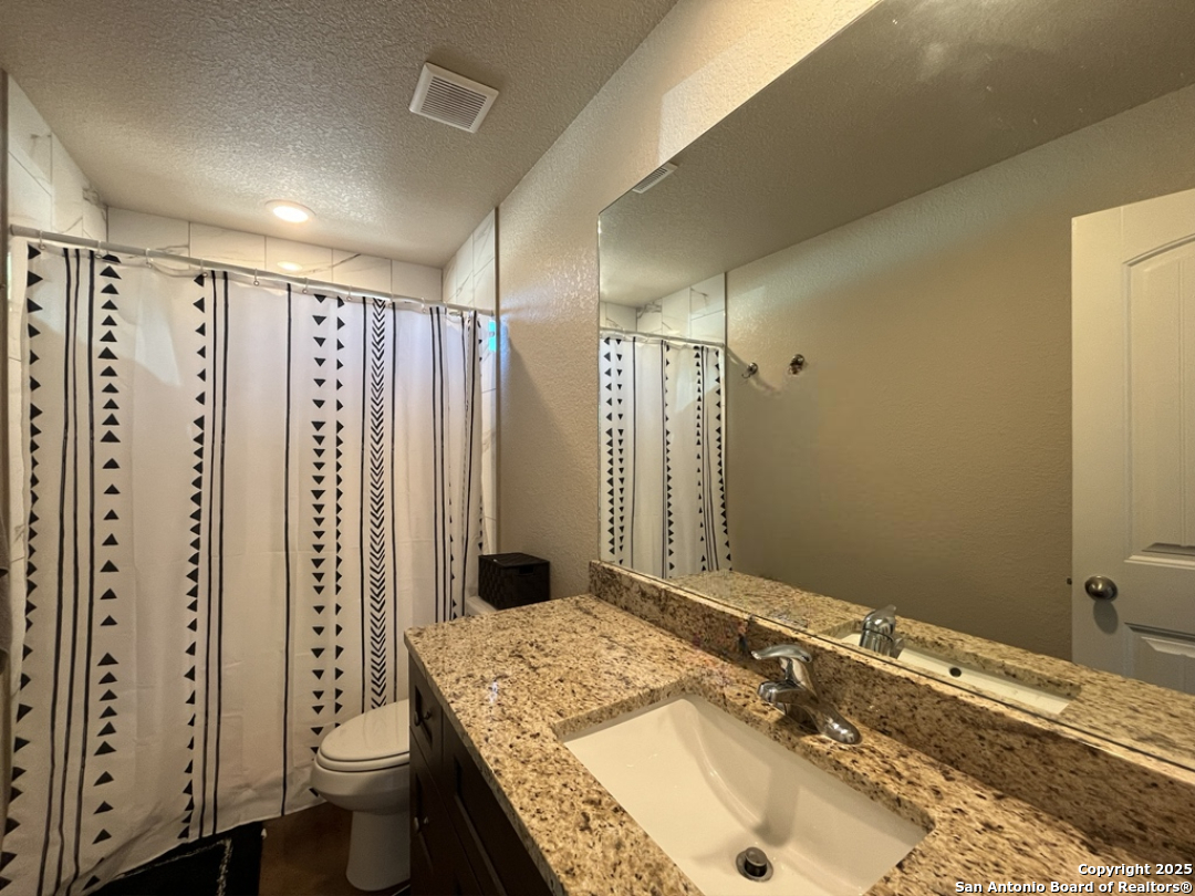 2708 Golf Drive Spring Branch, TX 78070 - Photo 14 of 31 a bathroom with a granite countertop sink toilet and shower